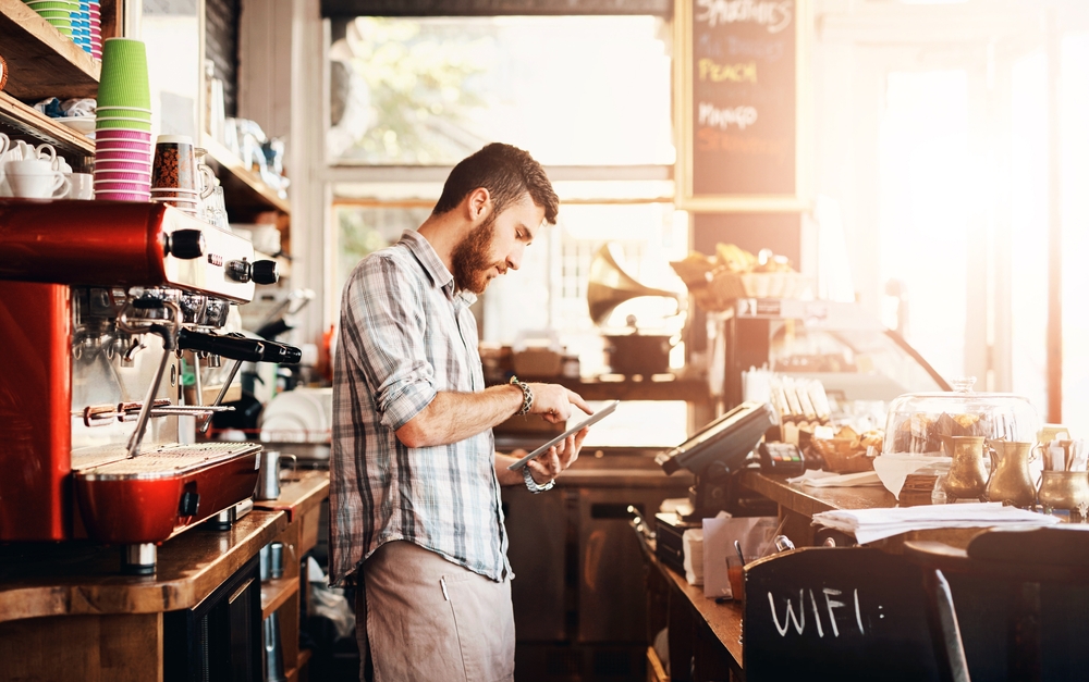 A food business owner managing orders on a tablet